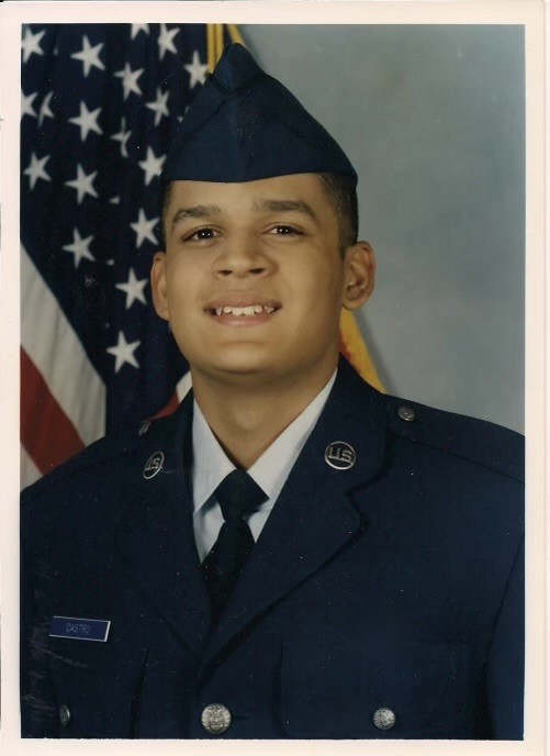 Jason Castro in U.S. Air Force service dress at basic training, in front of the American flag.